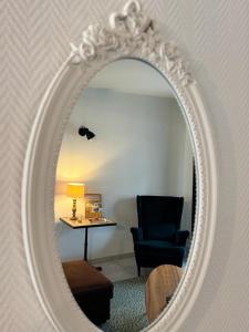 a mirror with a chair and a table in a room at La Petite Maison in Montbard +9 photos