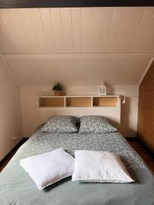 a bedroom with a bed with two pillows on it at La Petite Maison in Montbard