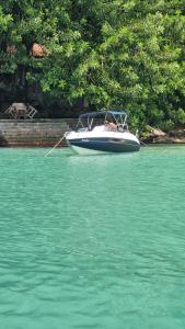 a small boat in the water with a rope at Lancha melodia in Paraty