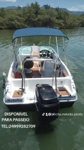 a white boat in the water on a river at Lancha melodia in Paraty +1 photo