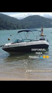 a boat sitting in the water on a lake at Lancha melodia in Paraty