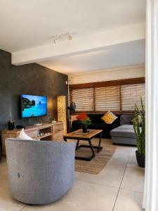 a living room with a couch and a table at Villa Ptit Bouchon - En face de la Plage - Facing beach with Ocean views in Bouchon