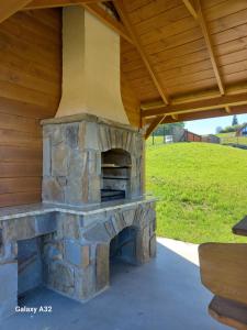 an outdoor brick oven under a wooden roof at Willa Widokowe Wzgórze in Falsztyn
