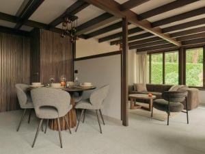 a dining room with a table and chairs and a couch at Yasu Stay Sonnevijver Rekem in Lanaken