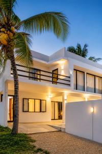 a house with a palm tree in front of it at Villa Ptit Bouchon - En face de la Plage - Facing beach with Ocean views in Bouchon