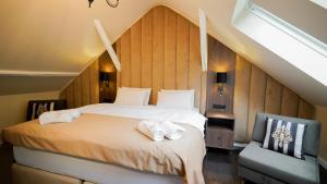 a bedroom with a large bed and a chair at Hotel Fatima in Trenčín