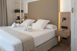 a bedroom with a bed with white sheets and pillows at Hotel Don Ignacio in San José
