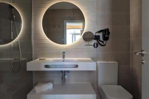 a bathroom with a sink and a mirror and a toilet at Hotel Don Ignacio in San José