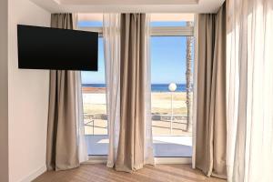 a room with a large window with a view of the ocean at Hotel Don Ignacio in San José