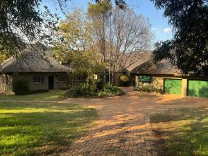 a house with a brick driveway in front of it at Shamwari Guesthouse in Kalkheuvel