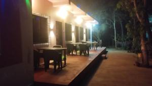 a row of tables and chairs on a patio at night at Sanvi Resort Malvan in Malvan
