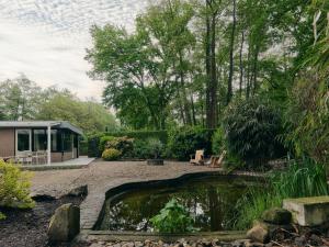 a garden with a pond in front of a house at Yasu Stay Sonnevijver Rekem in Lanaken