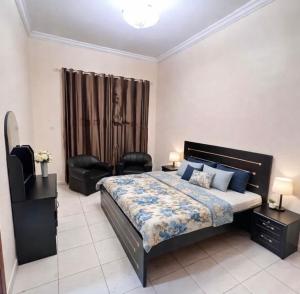 a bedroom with a bed and a chair in it at Abdulla al Shaiba in Jazīrat al Ḩibāb