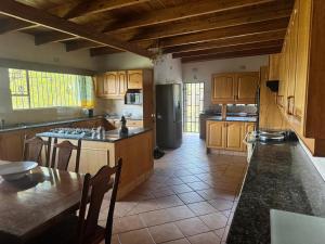 a kitchen with wooden cabinets and a table and a refrigerator at Shamwari Guesthouse in Kalkheuvel +20 photos