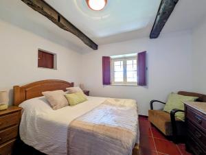 a bedroom with a bed and a window at Casas Telhadas in Trancoso