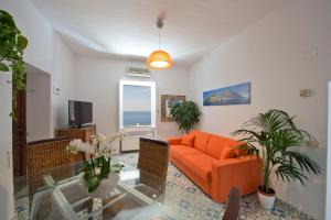 普萊伊亞諾的住宿－Casa Sunset，客厅配有橙色沙发和窗户