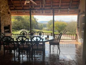 a dining room with a table and chairs and a large window at Shamwari Guesthouse in Kalkheuvel