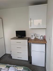 a bedroom with a desk with a computer and a tv at Corby Double & En-suite Rooms NN17 2LZ area Ideal Contractors Short & Long stays Opposite Lodge Park Leisure Center in Corby
