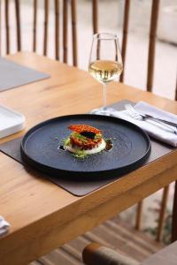 a plate of food and a glass of wine on a table at Albatros Beach & Resort in Rrogozhinë