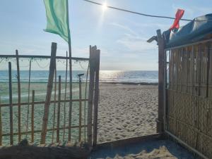 a gate on the beach with the ocean in the background at Elyu Seaside in San Juan