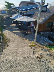 a group of tables and umbrellas in front of a building at Elyu Seaside in San Juan