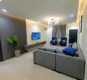 a living room with a couch and two blue chairs at House 234 in Ungwan Bado +4 photos