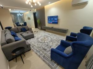 a living room with blue chairs and a couch at House 234 in Ungwan Bado