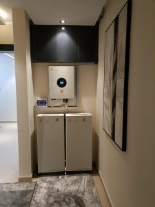 a small kitchen with a refrigerator and a microwave at House 234 in Ungwan Bado