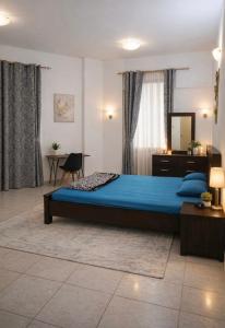 a bedroom with a bed and a table and a mirror at Abdulla al Shaiba in Jazīrat al Ḩibāb