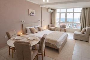 a bedroom with a large bed and a table and chairs at Sea View Apartment Rafailovići in Rafailovici