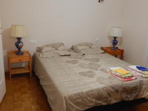 a bedroom with a bed with two lamps on two tables at Côte Landaise in Tarnos