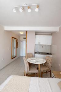 a kitchen and dining room with a table and chairs at Sea View Apartment Rafailovići in Rafailovici