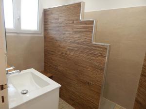 a bathroom with a sink and a wooden wall at Côte Landaise in Tarnos +14 photos