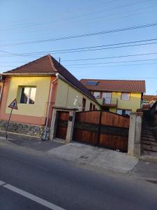 a house with a wooden gate and a fence at Casa Ruja in Ocna Sibiului
