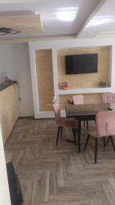 a living room with a table and chairs and a television at Casa Ruja in Ocna Sibiului