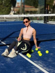a woman sitting on a tennis court with a bunch of tennis balls at Mountain View Hotel in Kyrenia