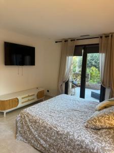 a bedroom with a bed and a flat screen tv at Maison de l'olivier in Taradeau