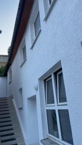 a white building with windows and stairs next to it at Modern apartment with space for 6 in Weißenfels