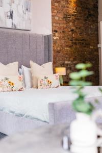 a bedroom with a bed with pillows and a brick wall at Mitre Hotel Manchester City Centre in Manchester