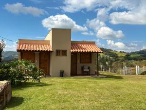 a small house with a green yard with a grass yard at Pousada Império de Minas in Capitólio +13 photos