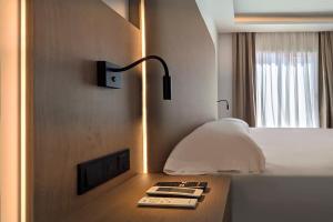 a room with a bed with a lamp and a remote control at Hotel Don Ignacio in San José +30 photos