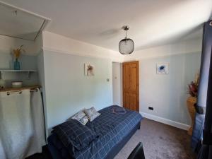 a bedroom with a blue bed in a room at Carisbrooke Mill Cottage in Newport