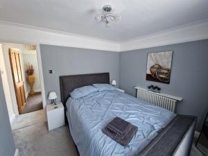 a bedroom with a large bed with a blue comforter at Carisbrooke Mill Cottage in Newport