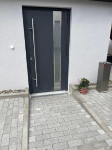 a blue door on a house with a potted plant at Ferienwohnung in der Langenau in Lichtenfels