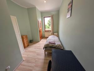 a small room with a bed and a window at Hostel Kalinowskiego in Żary