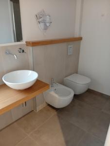 a bathroom with a sink and a toilet at La Porta Rossa House in Castelbuono