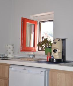 a kitchen with a counter top with a window at La Porta Rossa House in Castelbuono