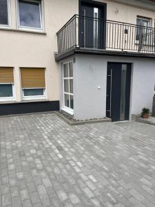 a house with a balcony and a patio at Ferienwohnung in der Langenau in Lichtenfels