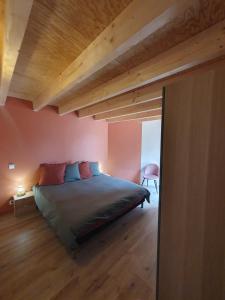 a bedroom with a bed in a room with wooden ceilings at Surf & Sauna Bud House in Longeville-sur-Mer