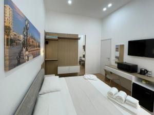 a large white room with a bed and a desk at Adriatic Breeze Rooms in Mola di Bari